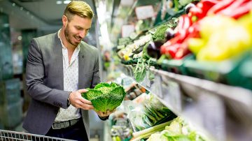 man picking fresh vegetables in shop