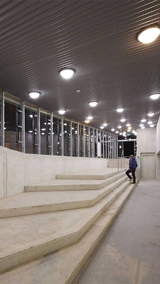  Man is climbing stairs at Eiteren parking garage illuminated by Philips lighting 