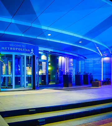 The doors to the Metropolitan building lit in blue corporate colours.